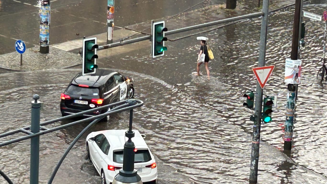 Durch den "Monsun": Eine Frau am Mittwochvormittag im knöcheltiefen Regenwasser – auf der Torstraße.