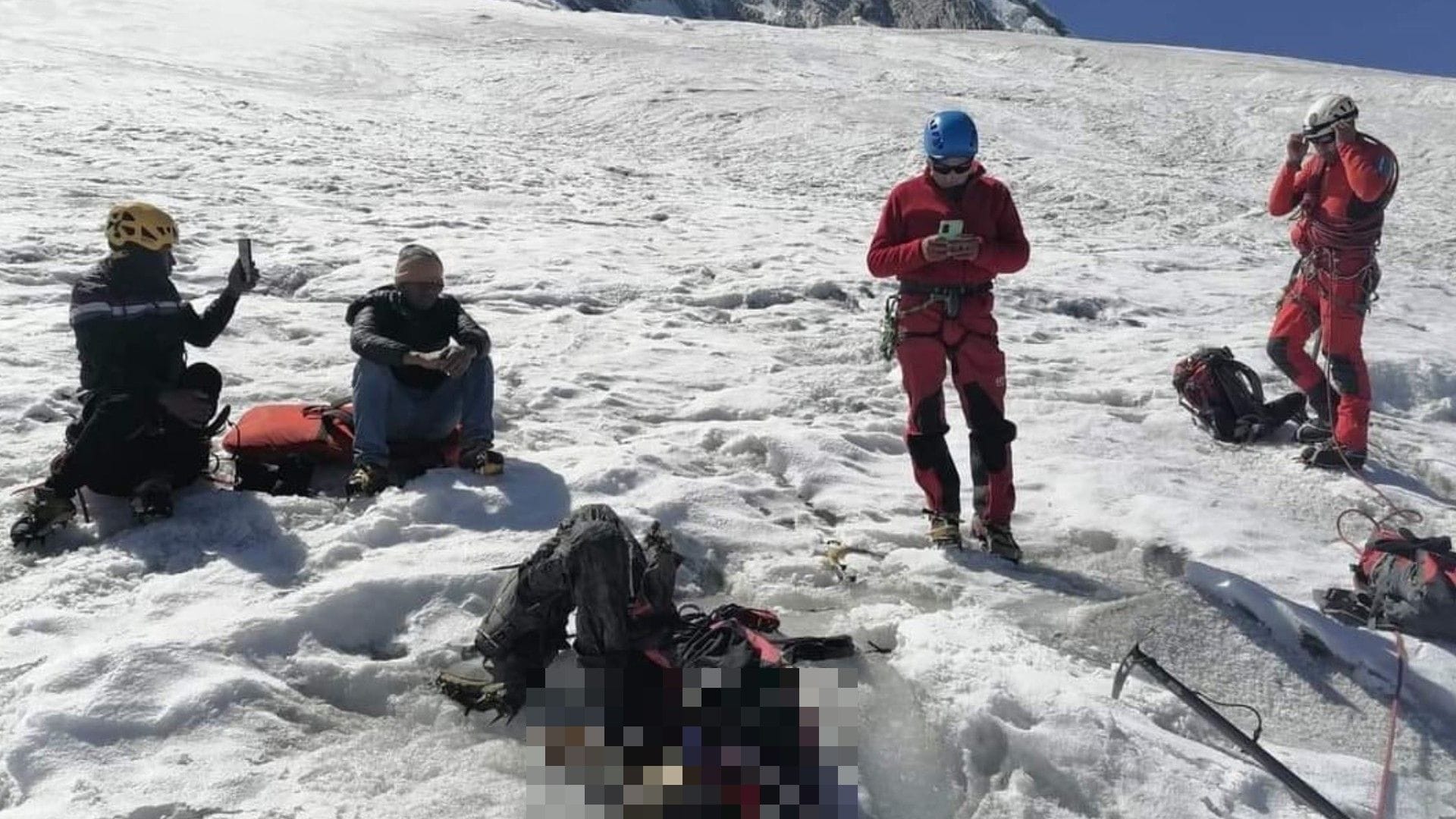 Eine Crew von Bergspezialisten der Polizei um die mumifizierte Leiche herum: Mittlerweile wurde der tote Bergsteiger geborgen.