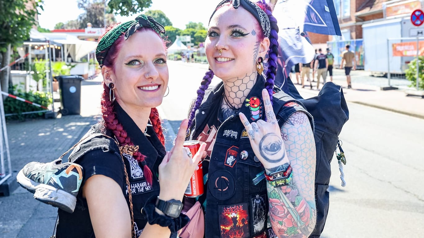 Wacken: Bodil (l, 24) und Lia (27), einheimische Festivalbesucher, feiern auf der Hauptstraße den Beginn des Wacken Open Air.