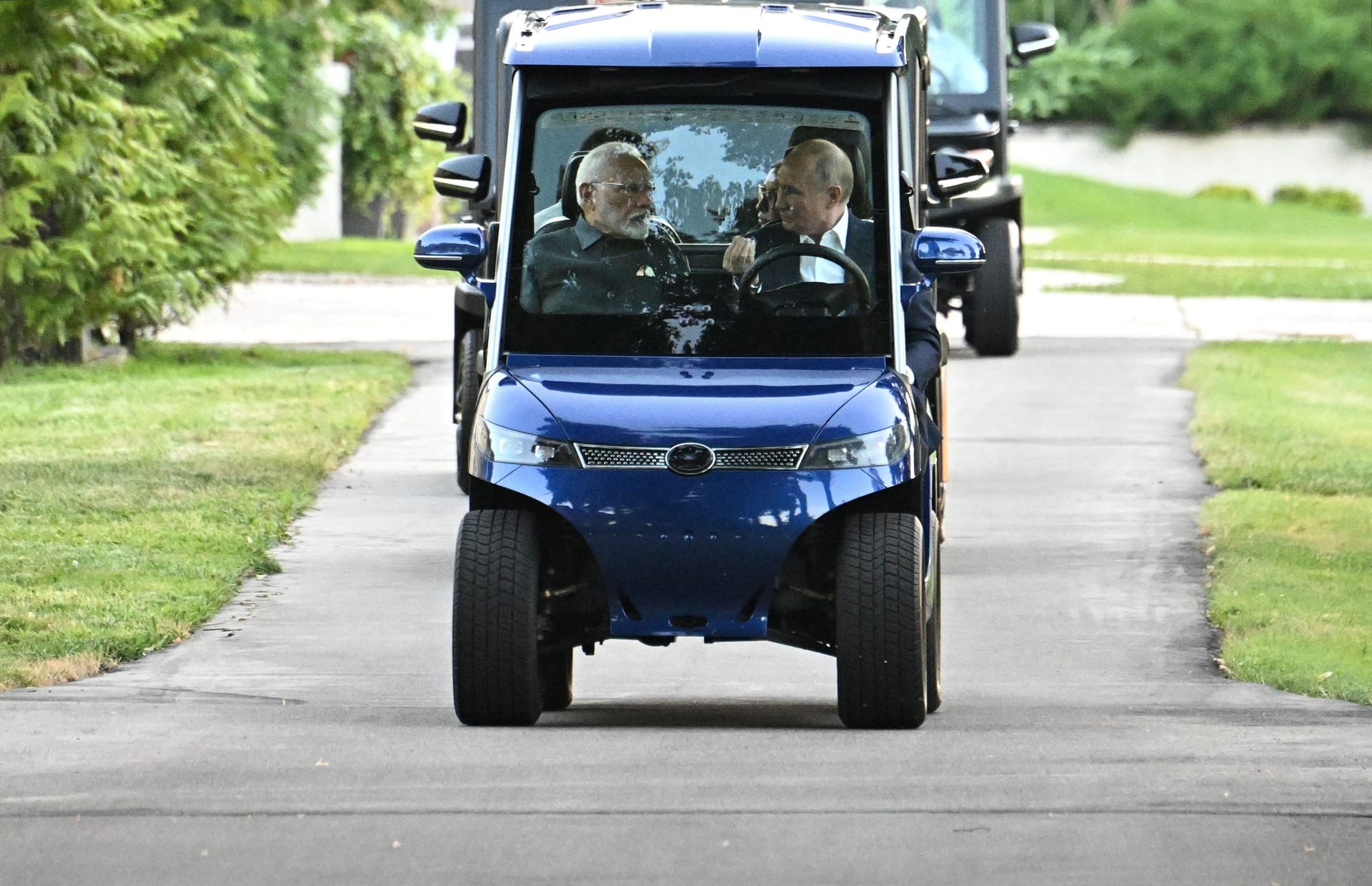 Putin kutschiert seinen treuen Verbündeten im Golf-Kart durch die Gegend.