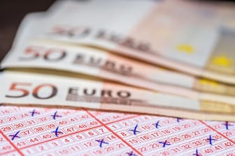 Geld auf einem Lottoschein (Symbolbild): Eine Person aus Berlin hat einen satten Lotteriegewinn abgestaubt.