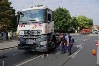 Polizisten inspizieren die Unfallstellen: Vier Stunden nach dem tödlichen Zusammenstoß lief der Einsatz noch immer.