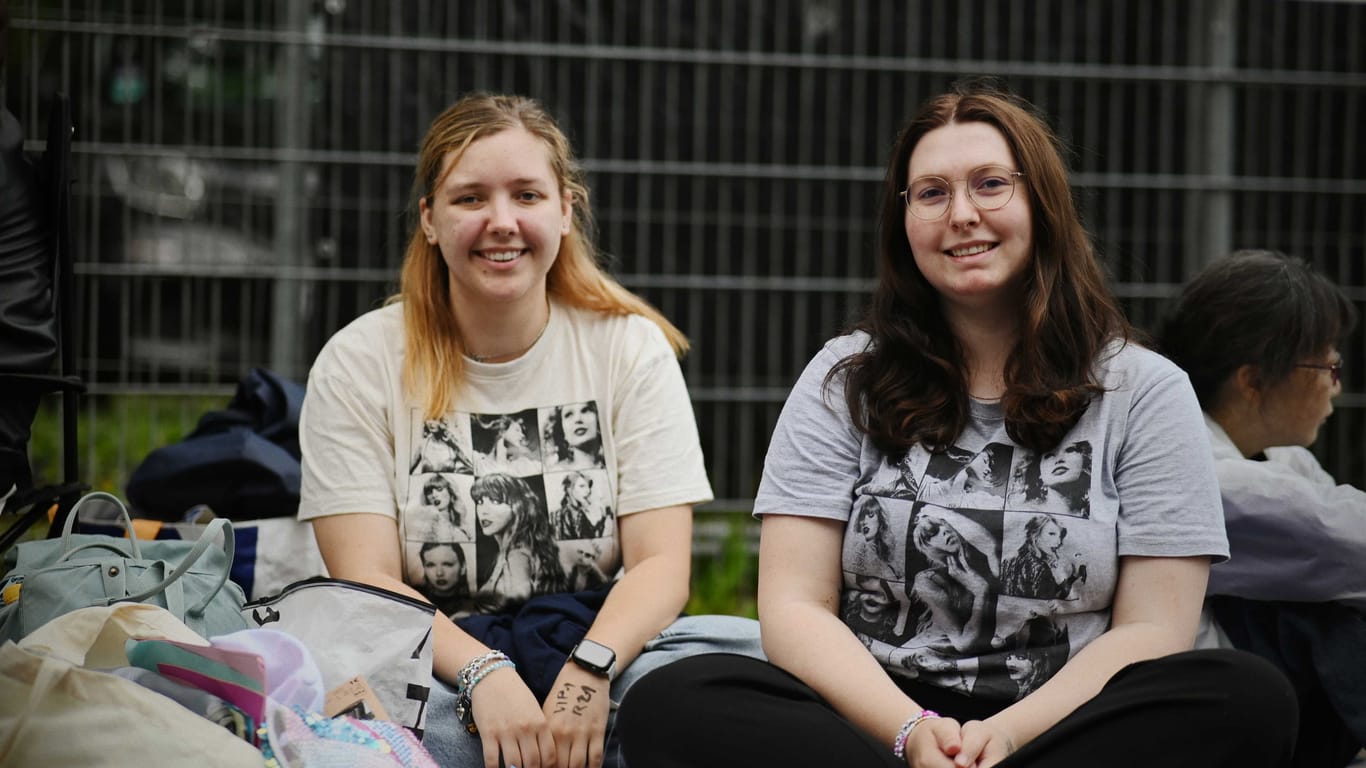 Taylor-Swift-Fans Amalie Demuth und Lilian Zawierucha sitzen vor dem Volksparkstadion.