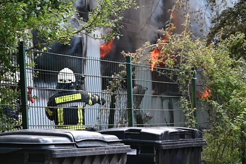 Feuerwehrleute löschen die brennende Unterkunft: Ein Mensch soll bei dem Feuer getötet worden sein.