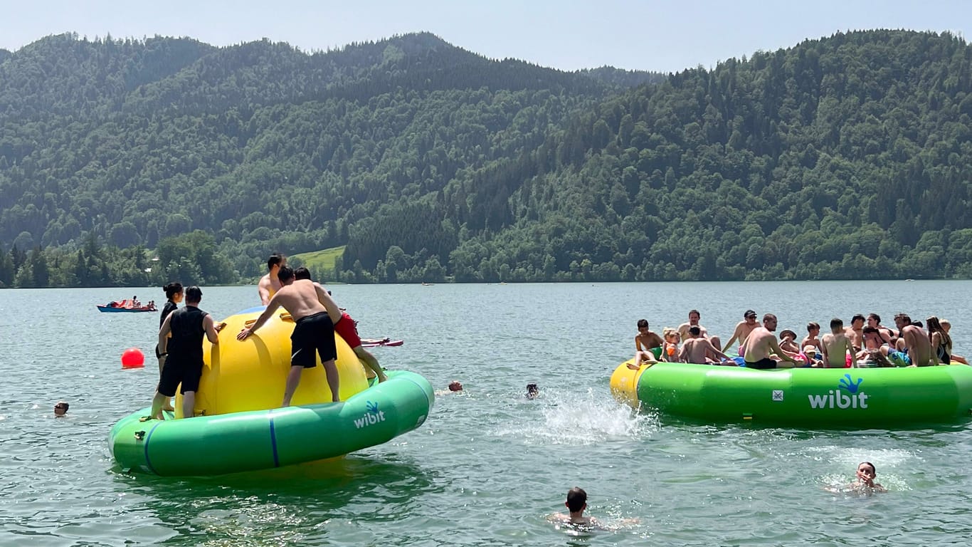 Badende am Schliersee in Bayern (Archivbild): Nun heißt es bundesweit "Pack die Badehose ein". In dieser Woche wird es sommerlich-heiß.