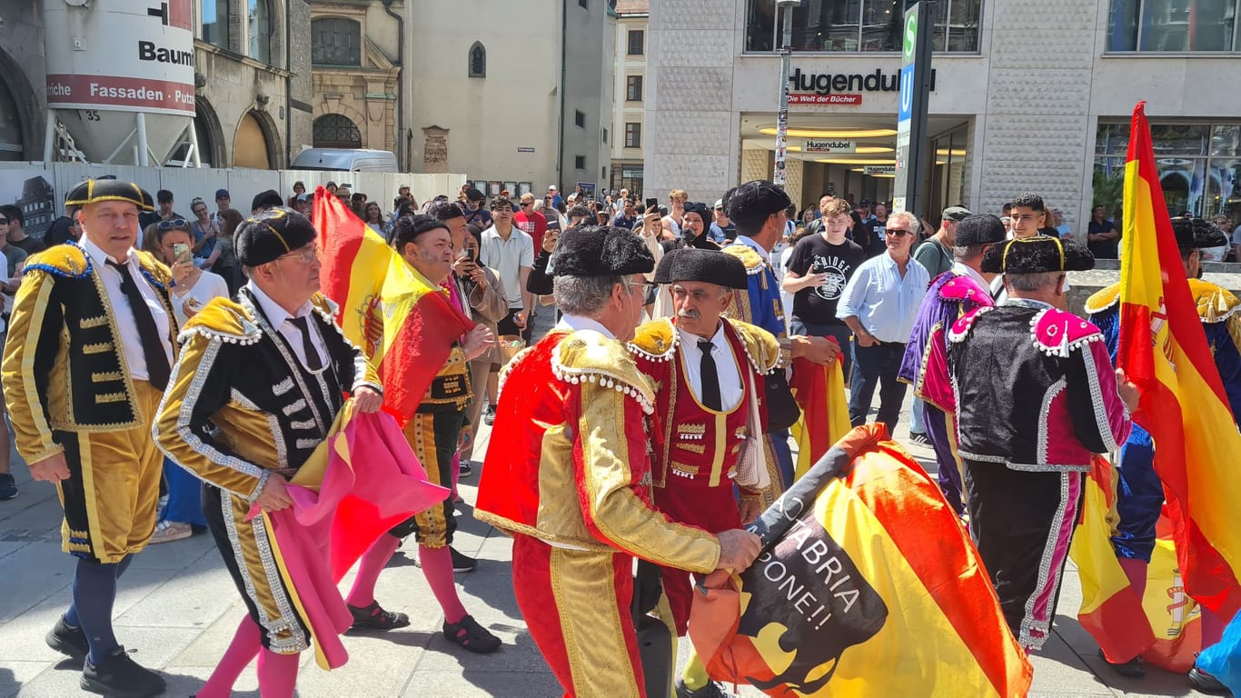 Ziehen alle Blicke auf sich: Eine Gruppe spanischer Fans läuft in Torero-Kostümen über den Marienplatz.