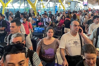 Menschen warten am Madrider Flughafen nach der weltweiten Computerstörung.