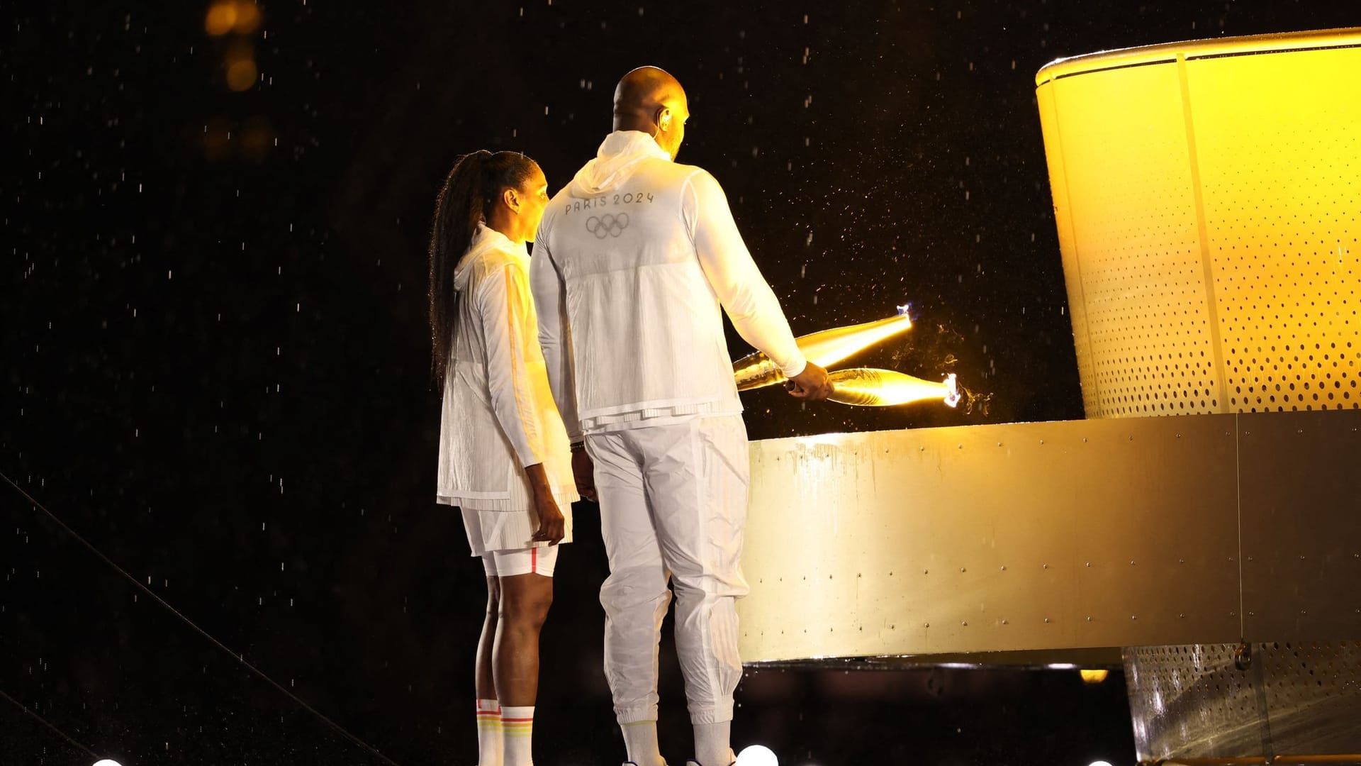 Teddy Riner und Marie-Jose Perec zünden das olympische Feuer an.