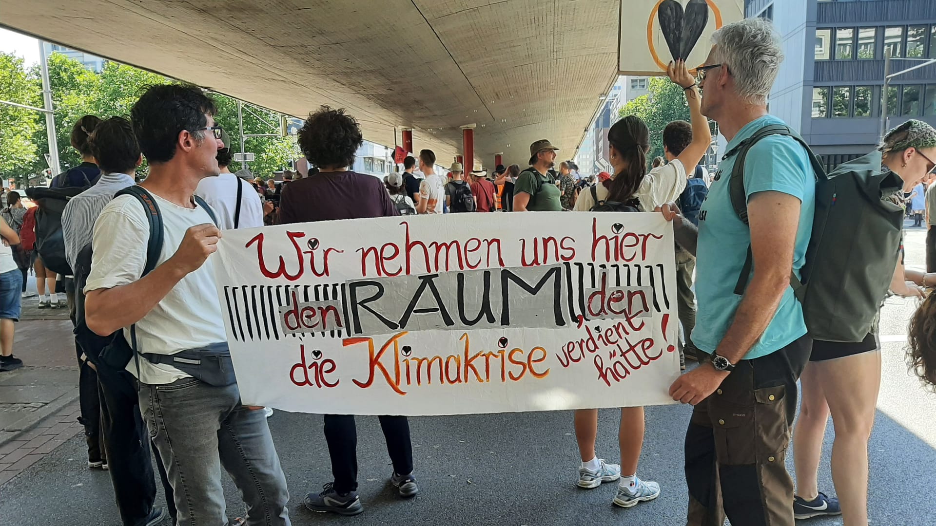 Klimaaktivisten stehen mit Plakaten vor dem Hauptbahnhof Bremen.