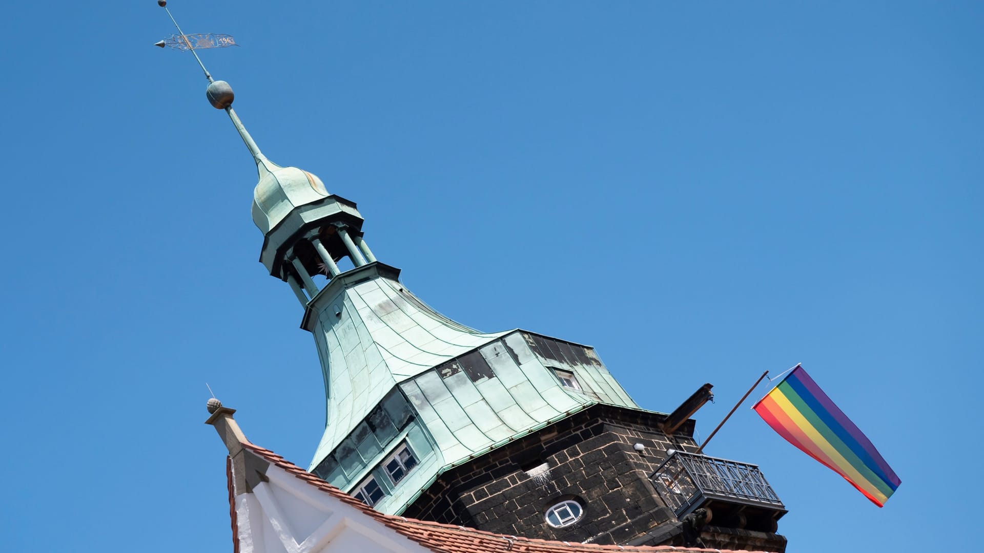 Eine Regenbogenfahne weht von der Marienkirche beim Christopher Street Day in Pirna. Der CSD in Pirna hat in diesem Jahr besondere Brisanz, da in der Stadt seit einigen Monaten ein AfD-naher Oberbürgermeister regiert.