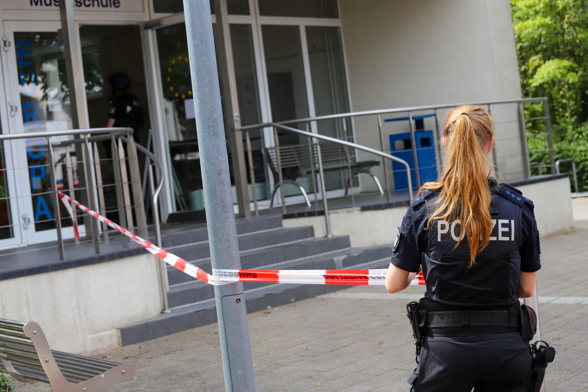 Eine Einsatzkraft sperrt das Gebäude der Musik- und Volkshochschule in Wedel ab.