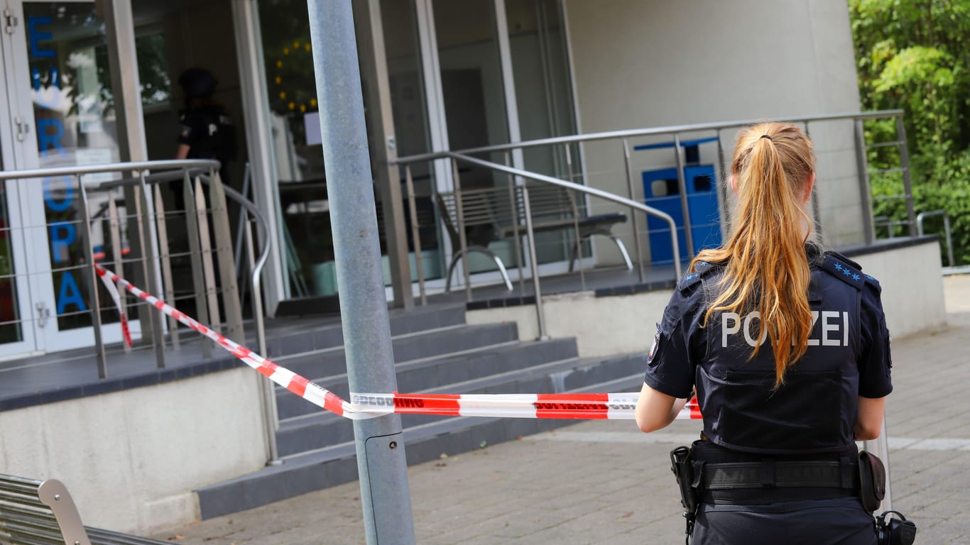 Eine Einsatzkraft sperrt das Gebäude der Musik- und Volkshochschule in Wedel ab.