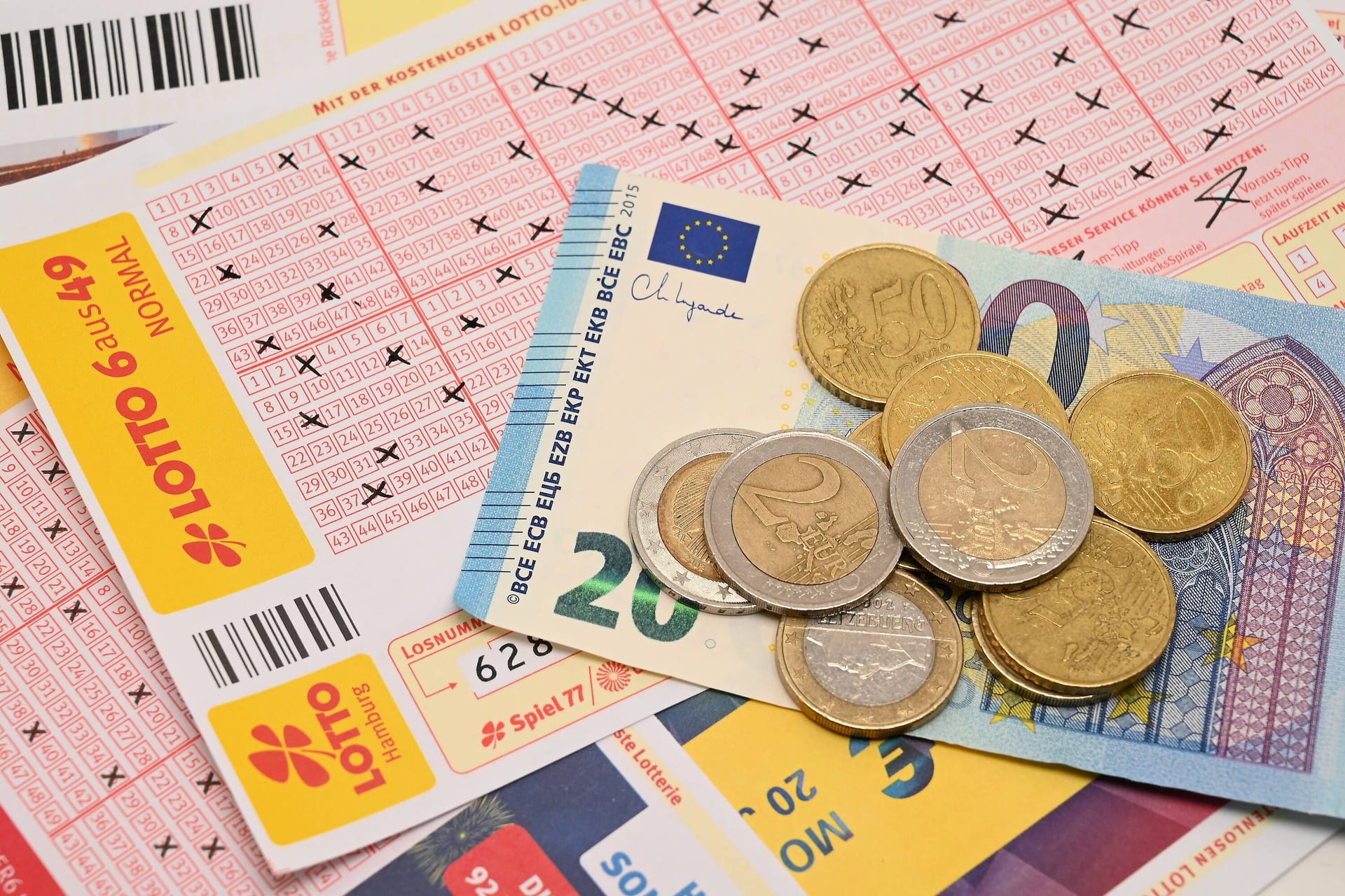 Lotto-Spielschein und Geld: Eine Hessin hat am Samstag viel Geld im Lotto gewonnen.