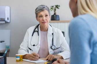 Eine Ärztin im Gespräch mit einer Frau: Ob es sich um eine Bartholin-Zyste handelt und ob diese behandelt werden sollte, lässt sich im Arztgespräch klären.