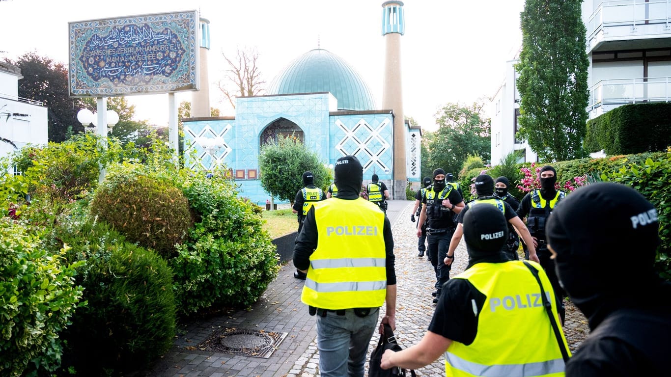 Einsatzkräfte der Polizei gehen während einer Razzia auf das Gelände vom Islamischen Zentrum Hamburg an der Außenalster.