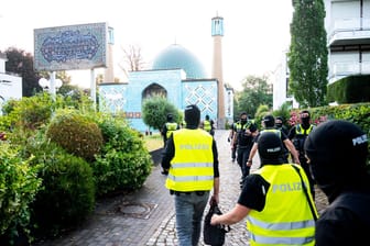 Einsatzkräfte der Polizei gehen während einer Razzia auf das Gelände vom Islamischen Zentrum Hamburg an der Außenalster.