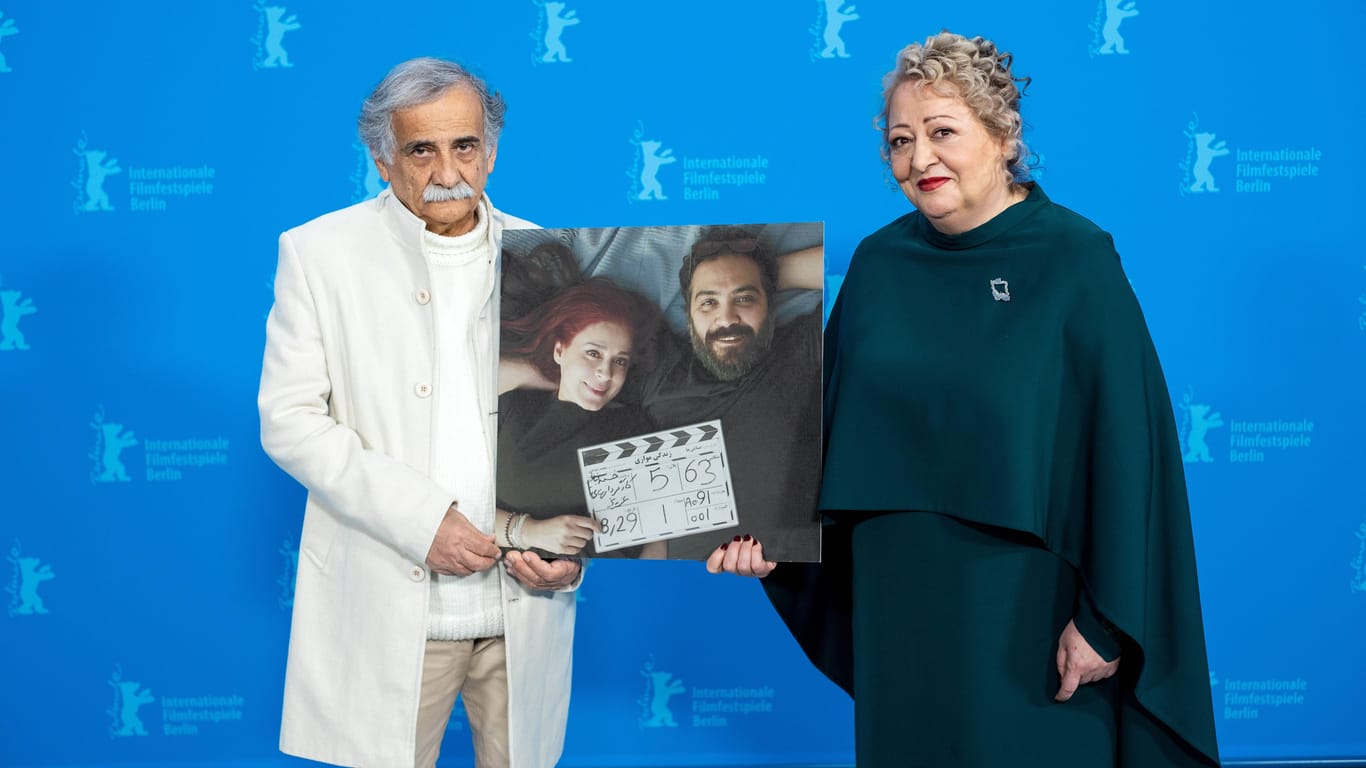 Schauspieler Esmail Mehrabi und Lily Farhadpour mit einem Bild der Regisseure Maryam Moghaddam und Behtash Sanaeeha bei der Berlinale.