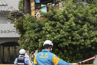 Polizisten stehen vor einem beschädigten Gebäude nach einem Erdbeben in Miyazaki.