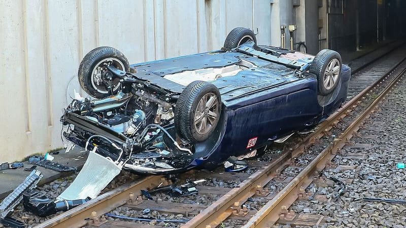 Ein Auto ist in Stuttgart von der Straße abgekommen, mehrere Meter tiefe gestürzt und liegt nun auf dem Dach auf den Bahngleisen der Linie U7.