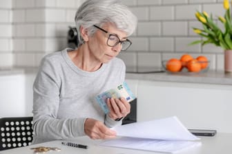 Ältere Frau prüft ihre Finanzen: Vor allem für die heute junge Generation dürfte die gesetzliche Rente nur noch als Grundversorgung taugen.