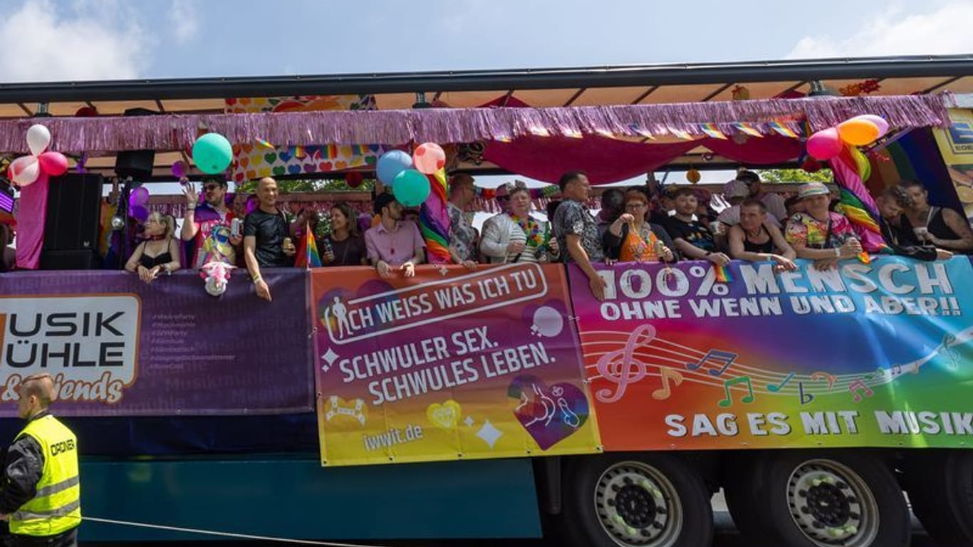 Menschen feiern bei der Parade zum Christopher Street Day in der Sächsischen Landeshauptstadt auf einem Wagen.