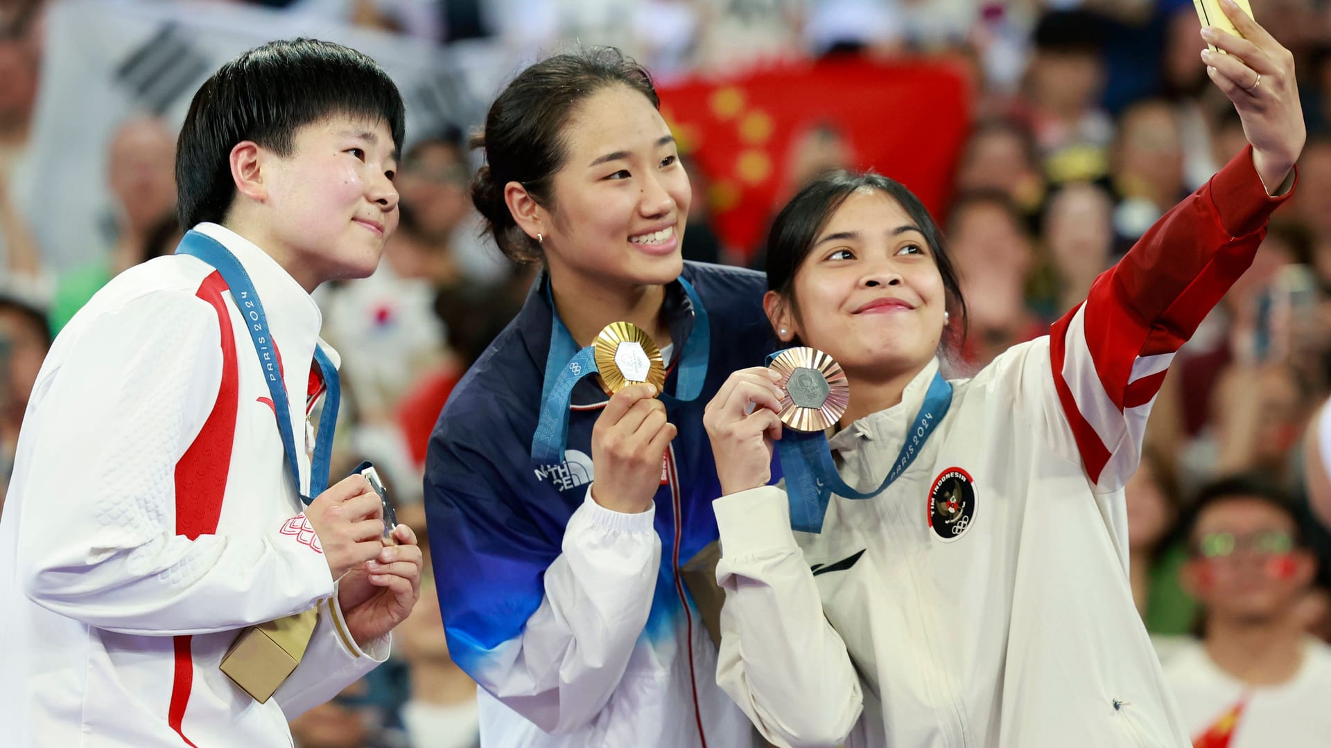 Fotos, selbst mit südkoreanischen Sportlerinnen: Die chinesische Badmintonspielerin He Bingjiaou (l) macht zusammen mit An Se Young (m) und Gregoria Mariska Tunjung aus Indonesien (r) ein Selfie.