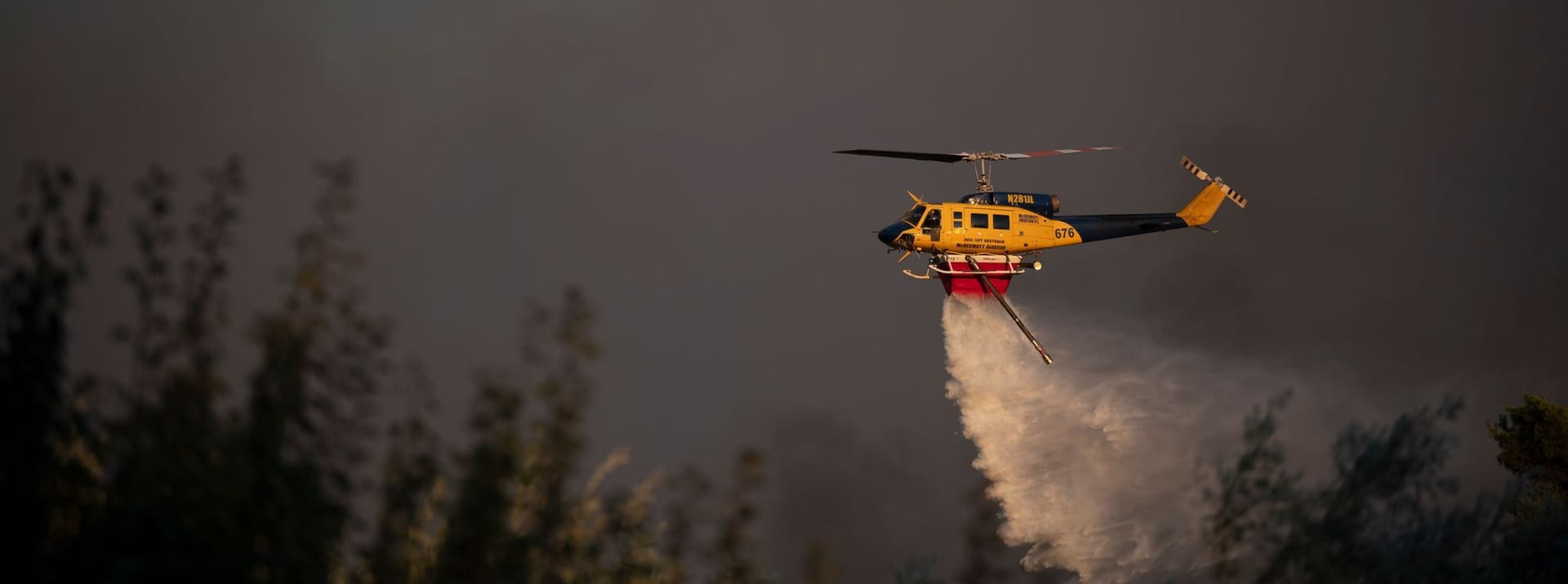 Ein Hubschrauber wirft während eines Waldbrandes in der Nähe des Dorfes Varnava Wasser ab.