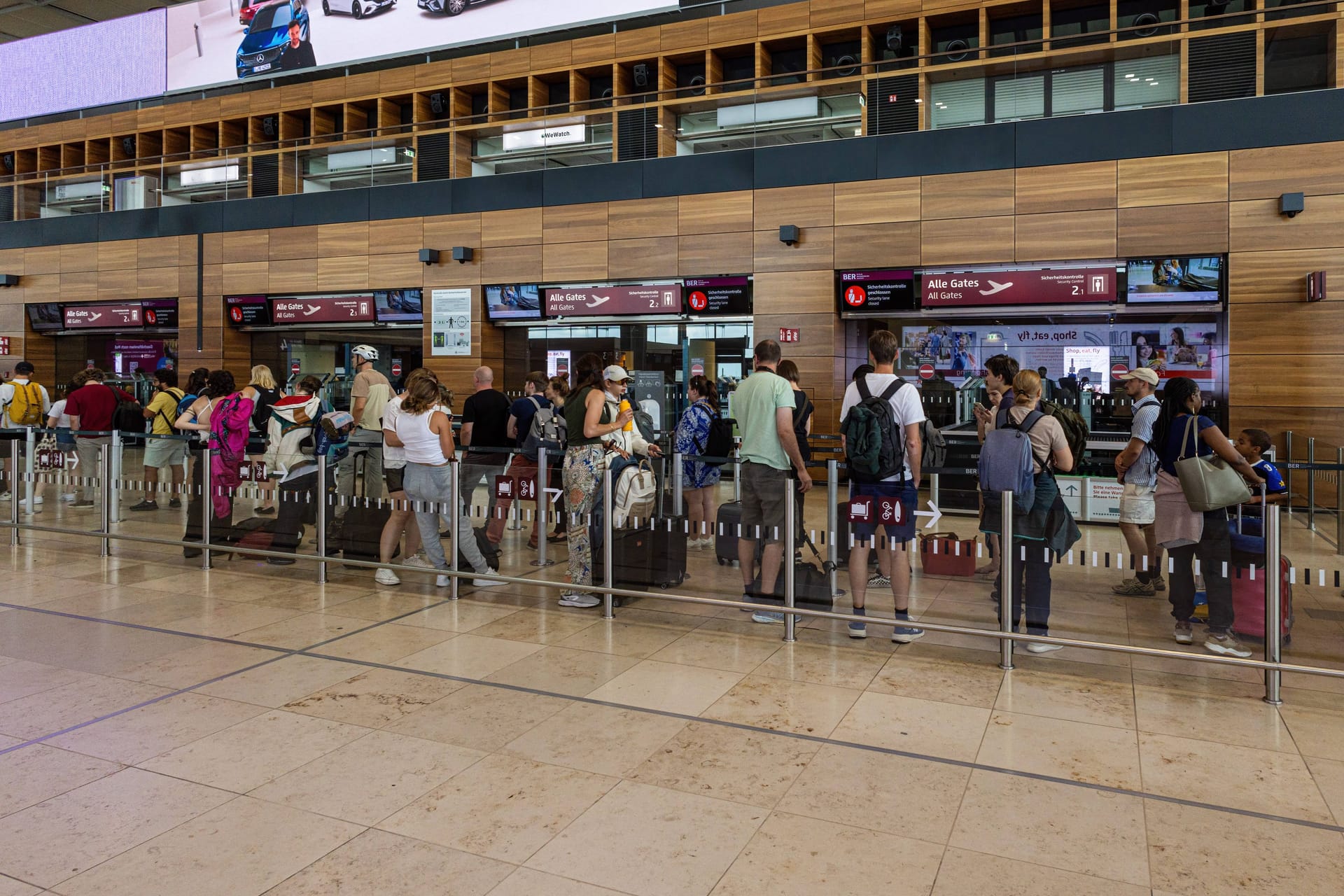 Reisende warten an der Sicherheitskontrolle des Berlin Brandenburg International Airports: Wer einen bestimmten Service nutzt, kann hier lange Wartezeiten verhindern.