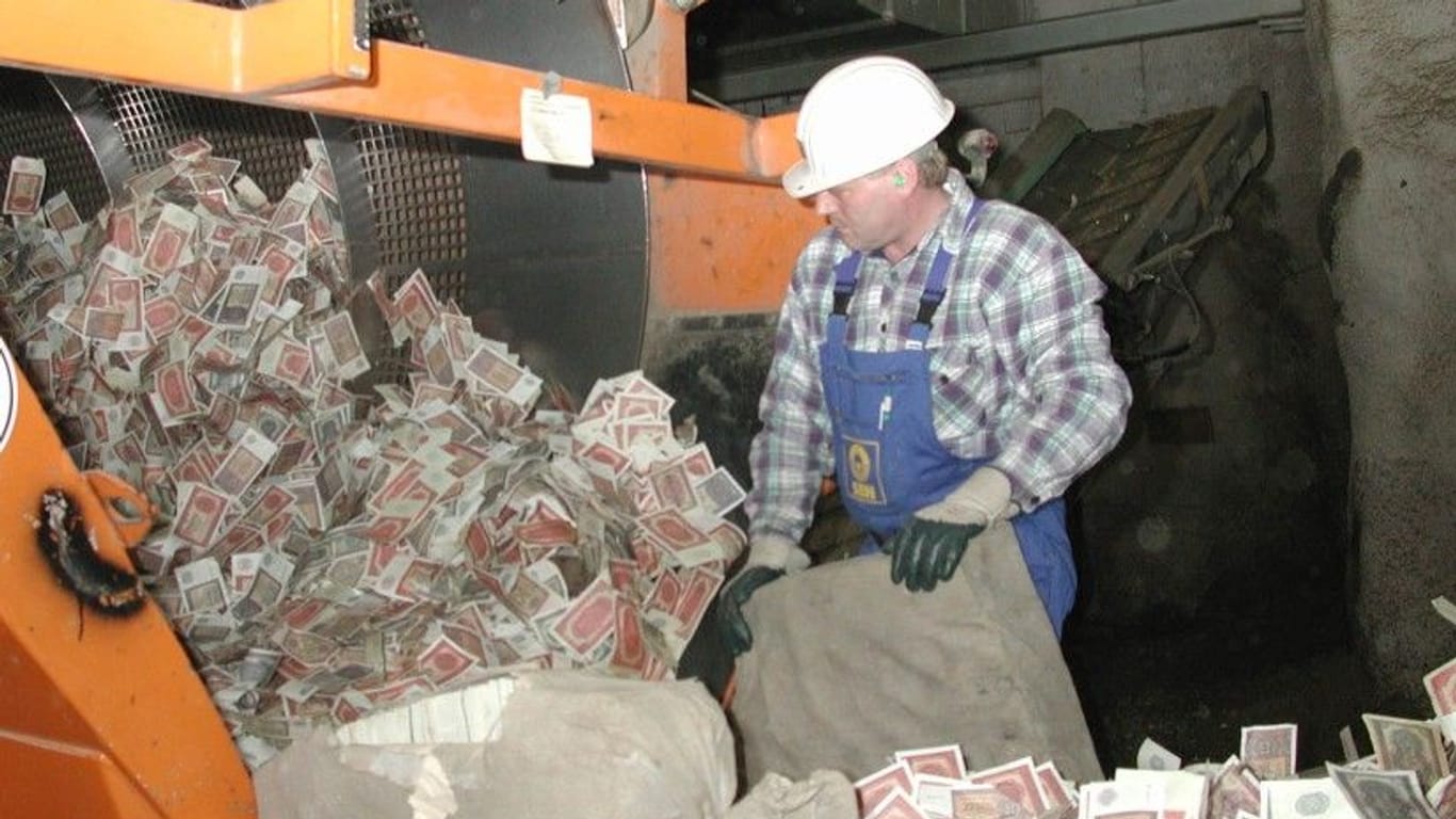 Vor der Verbrennung 2002: In einem Trommelsieb wird das Geld von Sand und Kies gesäubert.