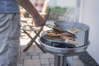 Ein Mann grillt (Symbolbild): Ein großer deutscher Grillshop steht vor dem Aus.