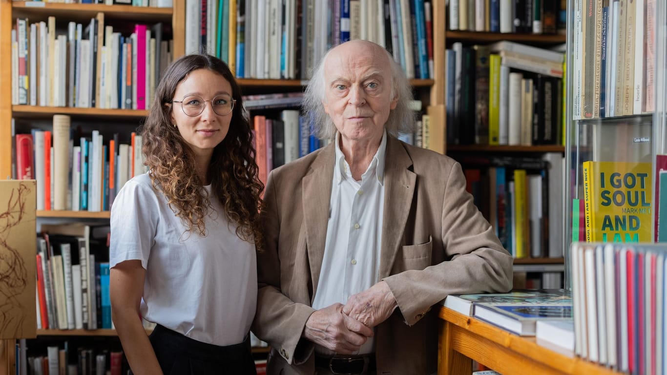 Antiquar Klaus Willbrand und Geschäftspartnerin Daria Razumovych stehen zwischen Büchern in seinem Antiquariat in Sülz.