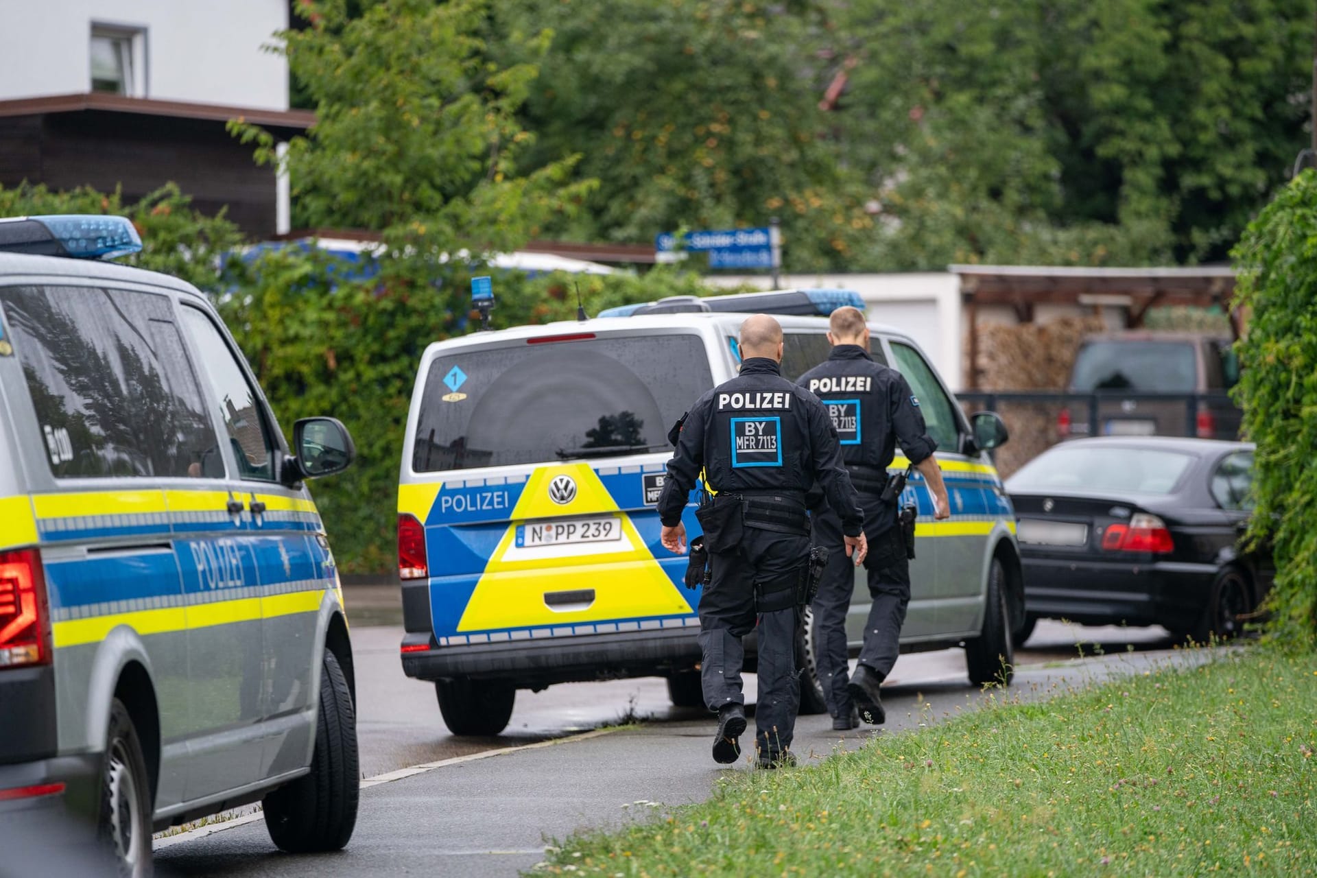 Polizisten sind in der Nähe des Tatorts in Schwabach im Einsatz. Dort war am Montagmorgen ein toter Mann auf offener Straße gefunden worden.