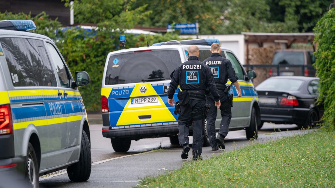 Polizisten sind in der Nähe des Tatorts in Schwabach im Einsatz. Dort war am Montagmorgen ein toter Mann auf offener Straße gefunden worden.