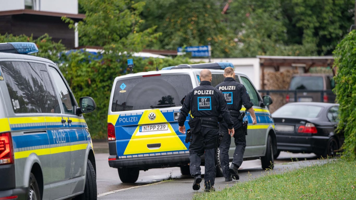 Polizisten sind in der Nähe des Tatorts in Schwabach im Einsatz. Dort war am Montagmorgen ein toter Mann auf offener Straße gefunden worden.