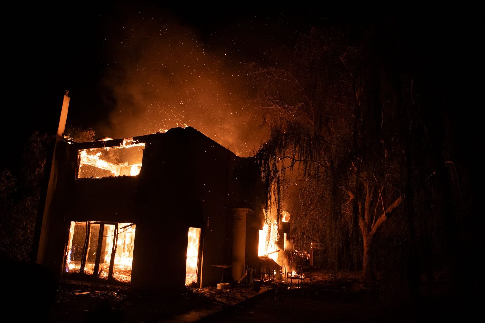 Ein Haus brennt während eines Waldbrandes im Dorf Varnava, nördlich von Athen.