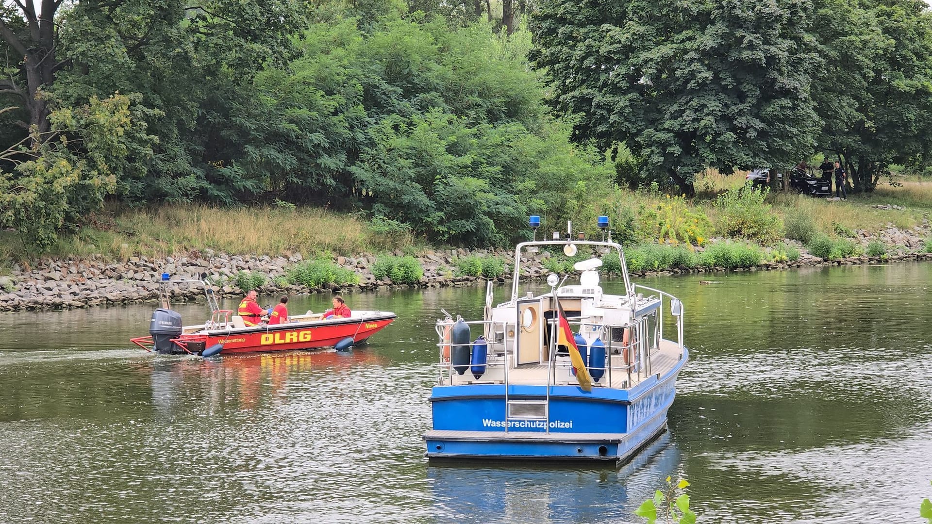 In Brandenburg/Havel fahren Boote der Wasserschutzpolizei und der DLRG auf dem Silokanal, nachdem hier eine Leiche gefunden wurde.