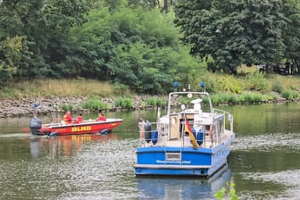 In Brandenburg/Havel fahren Boote der Wasserschutzpolizei und der DLRG auf dem Silokanal, nachdem hier eine Leiche gefunden wurde.