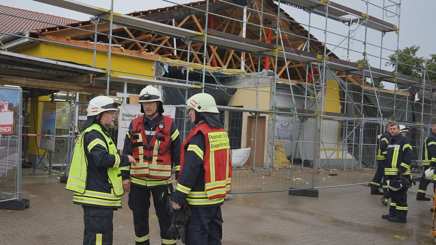 Feuerwehrleute vor dem beschädigten Discounter: Wegen Umbauarbeiten war das Dach offen und anfällig für den Sturm.