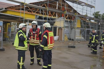 Feuerwehrleute vor dem beschädigten Discounter: Wegen Umbauarbeiten war das Dach offen und anfällig für den Sturm.