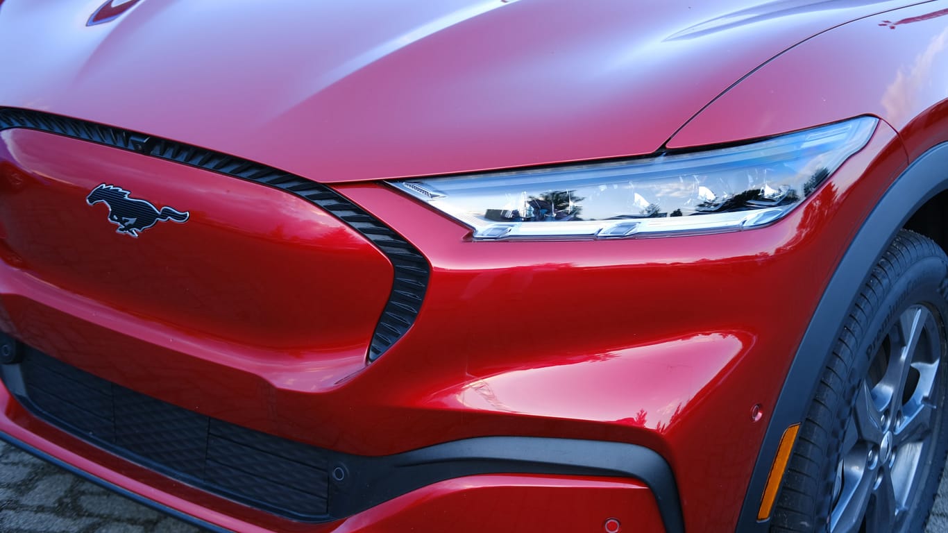 head lights of Electric Ford Mustang Mach-E on display in parking lot of company store specializing in sale of electric vehicles, alternative energy, Frankfurt - May 2023