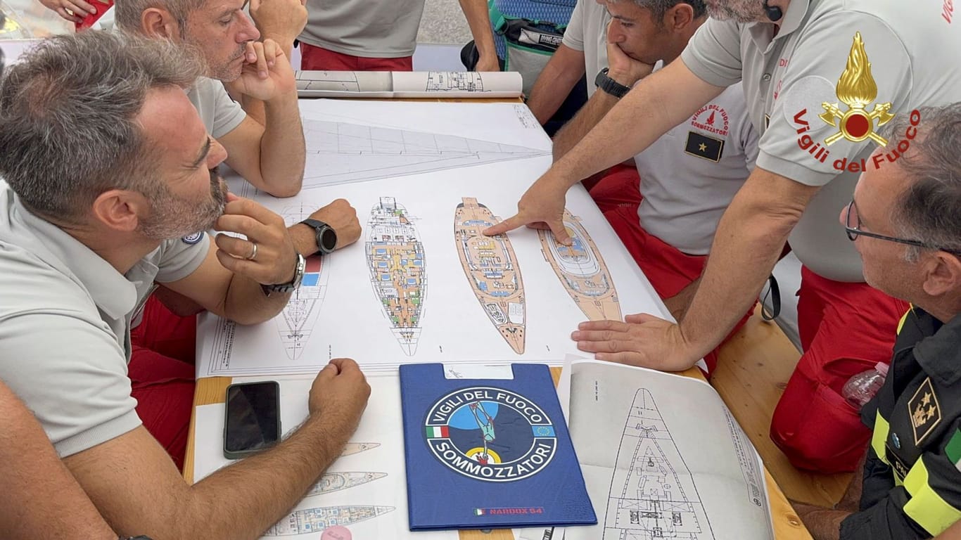 Taucher studieren eine Karte der Segeljacht «Bayesian» im Hafen von Porticello.