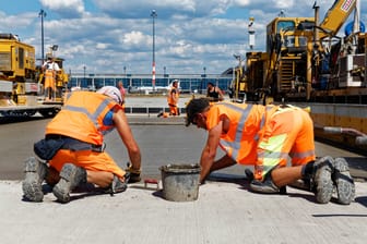 2020: Bauarbeiter betonieren eine Eingangsfläche des Flughafens BER.