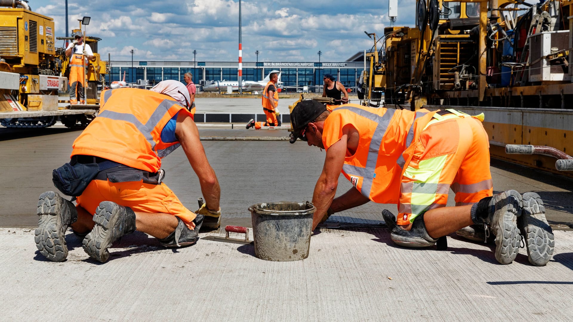 2020: Bauarbeiter betonieren eine Eingangsfläche des Flughafens BER.