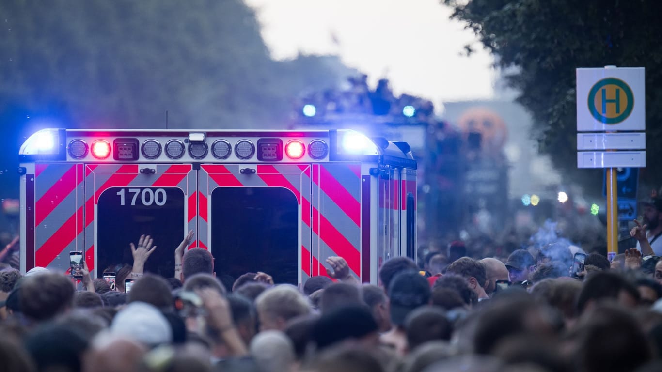 Ein Rettungswagen fährt zwischen den Teilnehmern auf der Technoparade "Rave The Planet" (Archivbild): Die Polizei hat eine Statistik zu der Veranstaltung veröffentlicht.