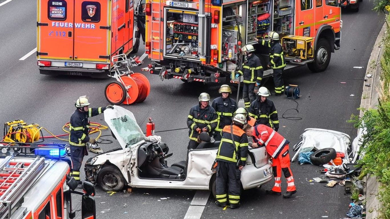 Feuerwehrleute an der Unfallstelle: Um den Fahrer zu befreien, musste das Dach des Autos abgesägt werden.