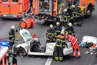 Feuerwehrleute an der Unfallstelle: Um den Fahrer zu befreien, musste das Dach des Autos abgesägt werden.