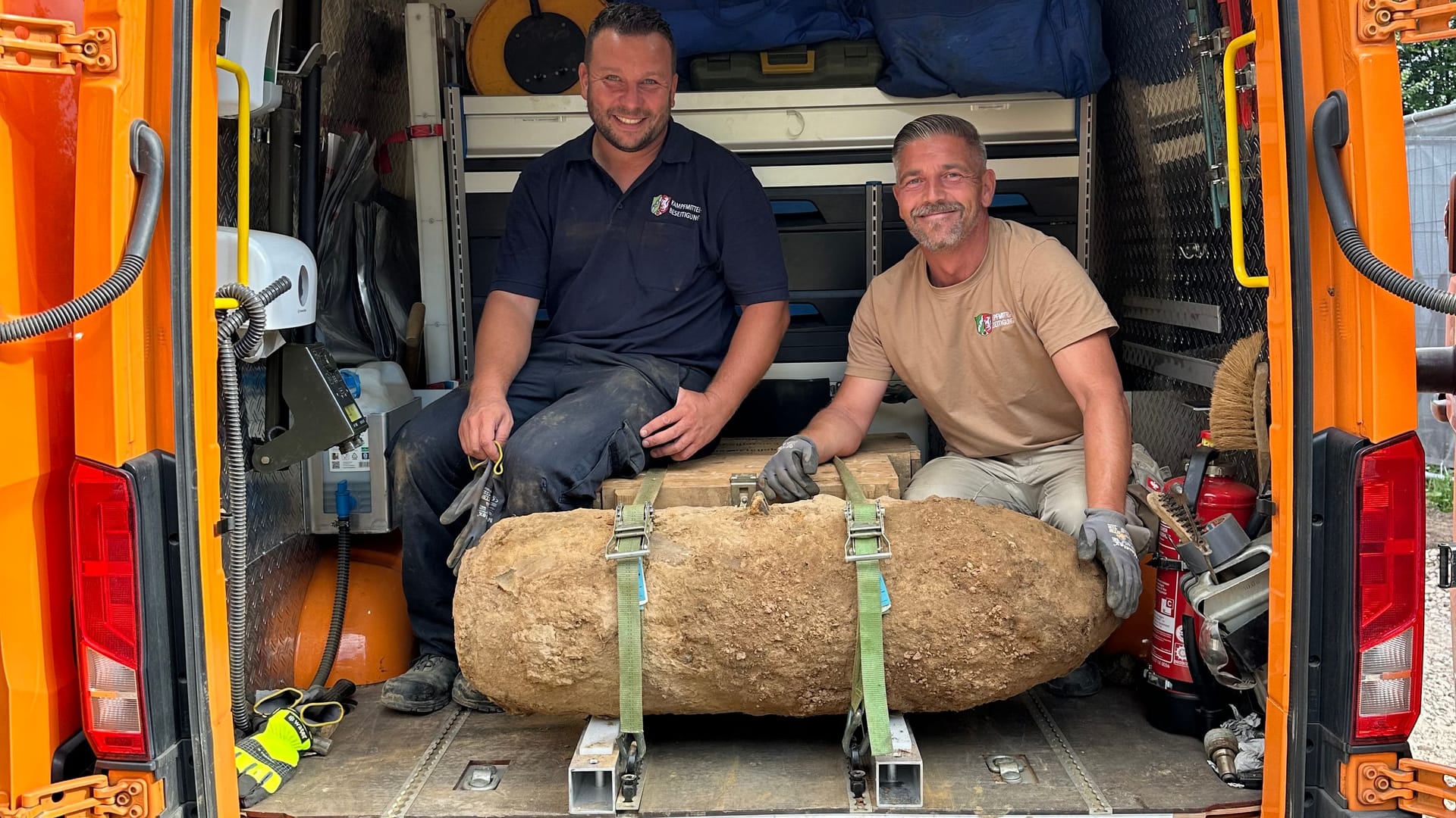 Phillip Blens und Marcel Biewald, Mitarbeitende des Kampfmittelbeseitigungsdienstes mit der entschärften Bombe.