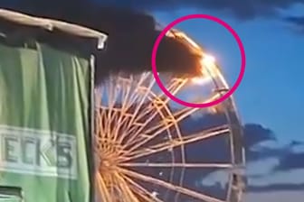 Ein Riesenrad auf einem Festivalgelände brennt.