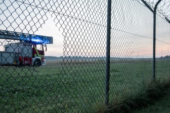 Ein Feuerwehrauto hinter dem Loch im Zaun: Hier drangen die Aktivisten mutmaßlich in den Sicherheitsbereich des Flughafens ein.