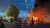 Festivalbesucher vor einem brennenden Riesenrad in Sachsen.